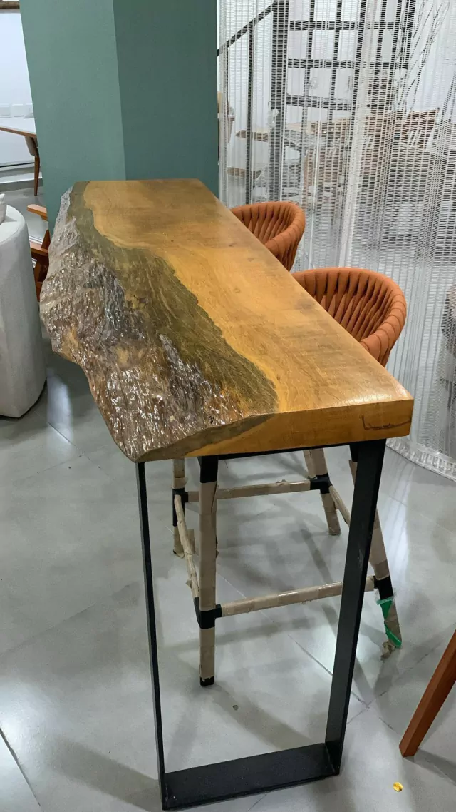 Aparador de madeira orgânica Pequia, frente com casqueiro e atrás reto, pés de ferro preto.